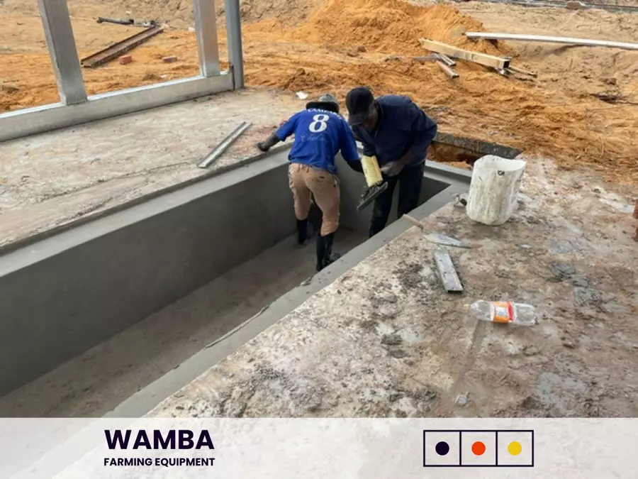 Workers plastering manure pit.